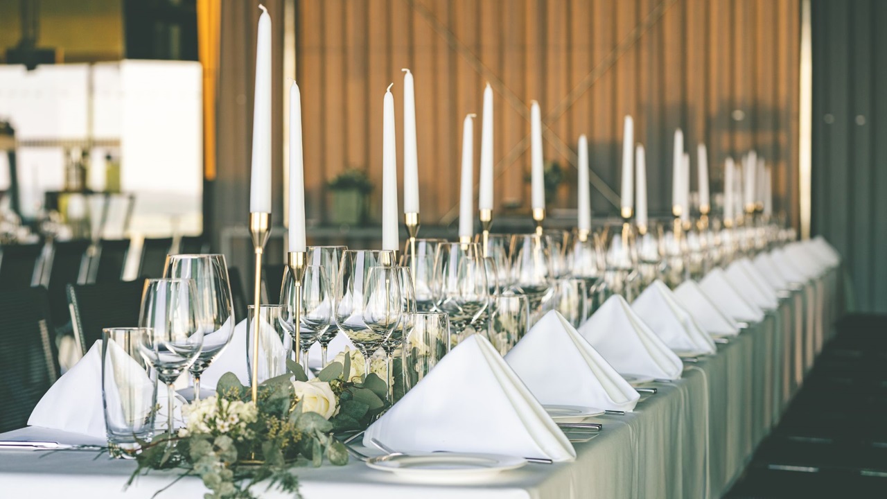 Gedeckter Hochzeitstisch mit weissen Kerzen und Servietten