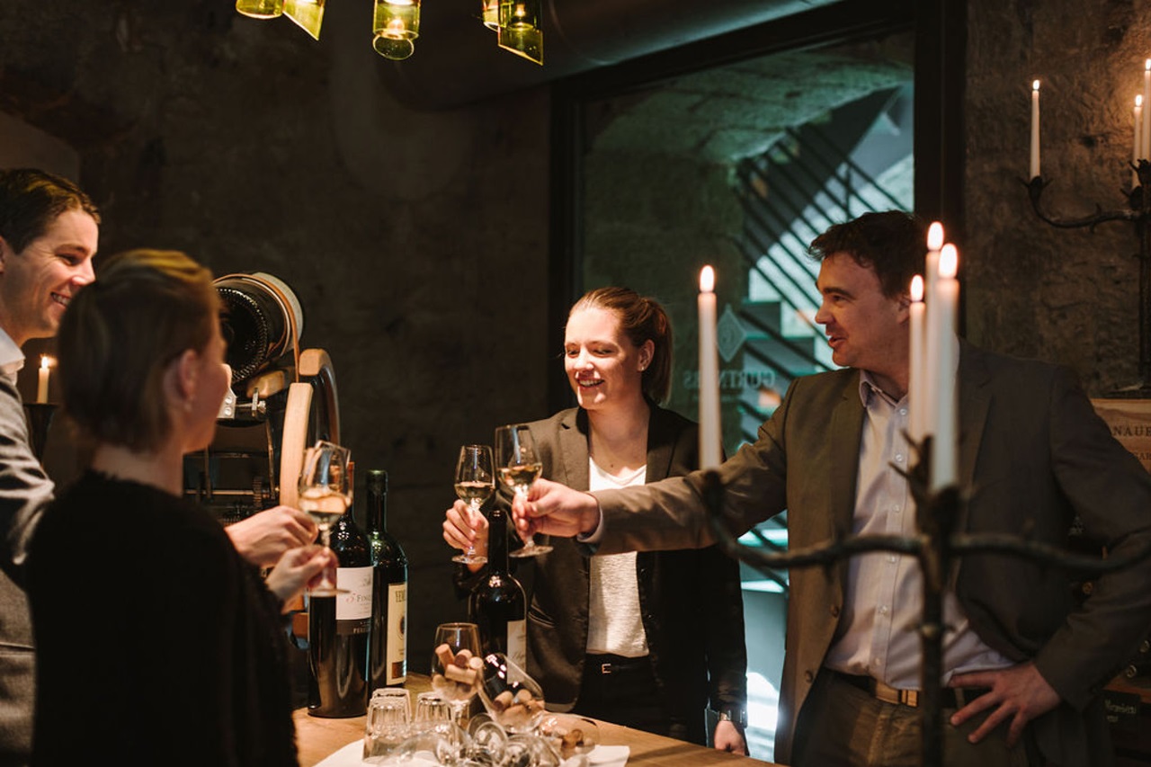 A group toast with white wine in the vaulted cellar