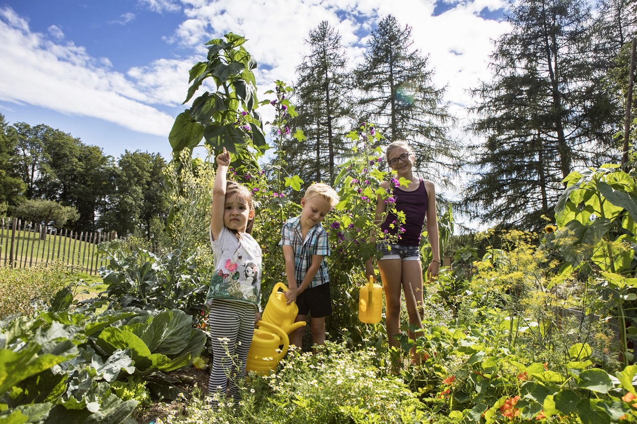 Children help in the garden while playing 
