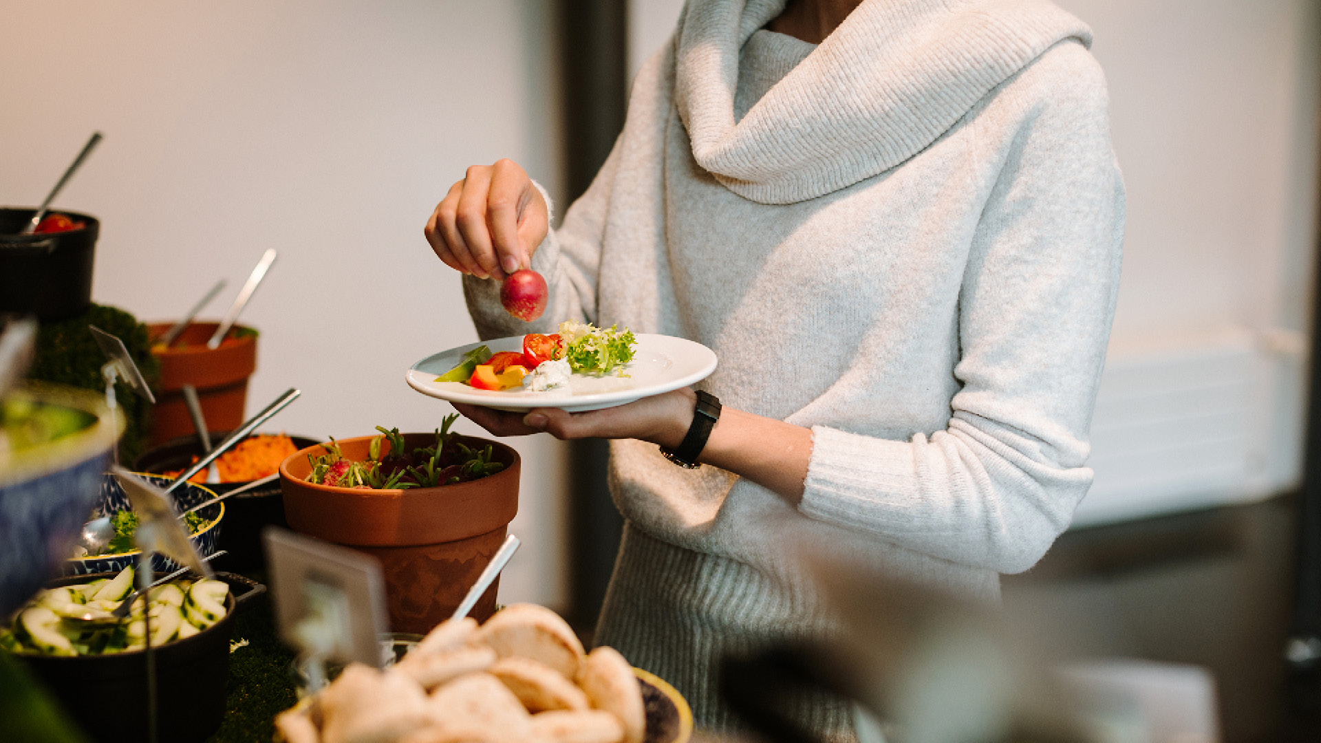 Frau bedient sich am Salatbuffet beim vegetarischen Kulturschür-Brunch