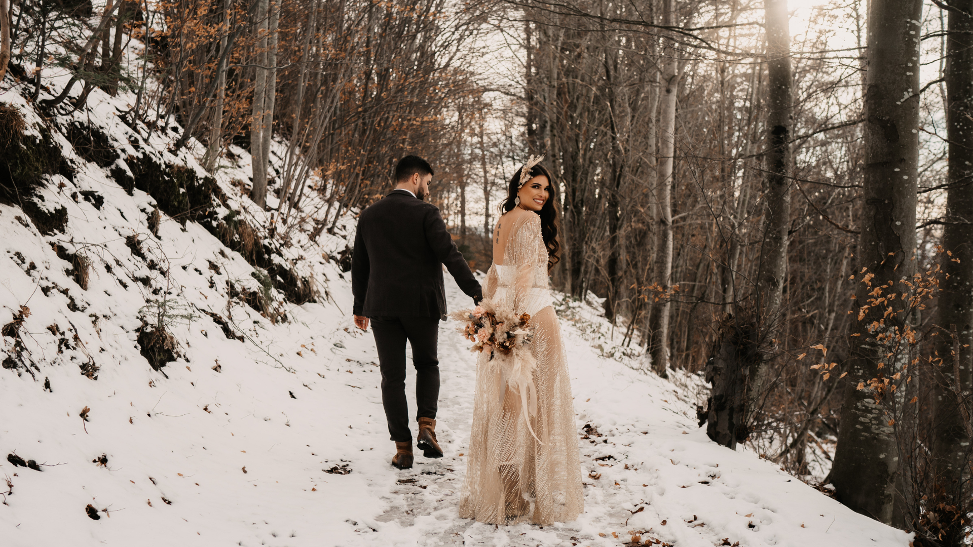 Les jeunes mariés marchent sur un chemin enneigé en hiver
