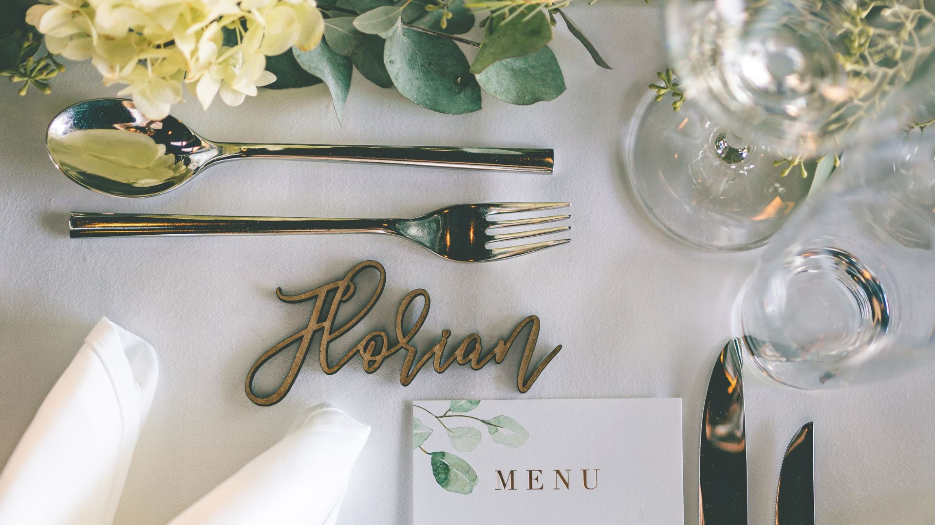 Festive table setting with menu card on white tablecloth