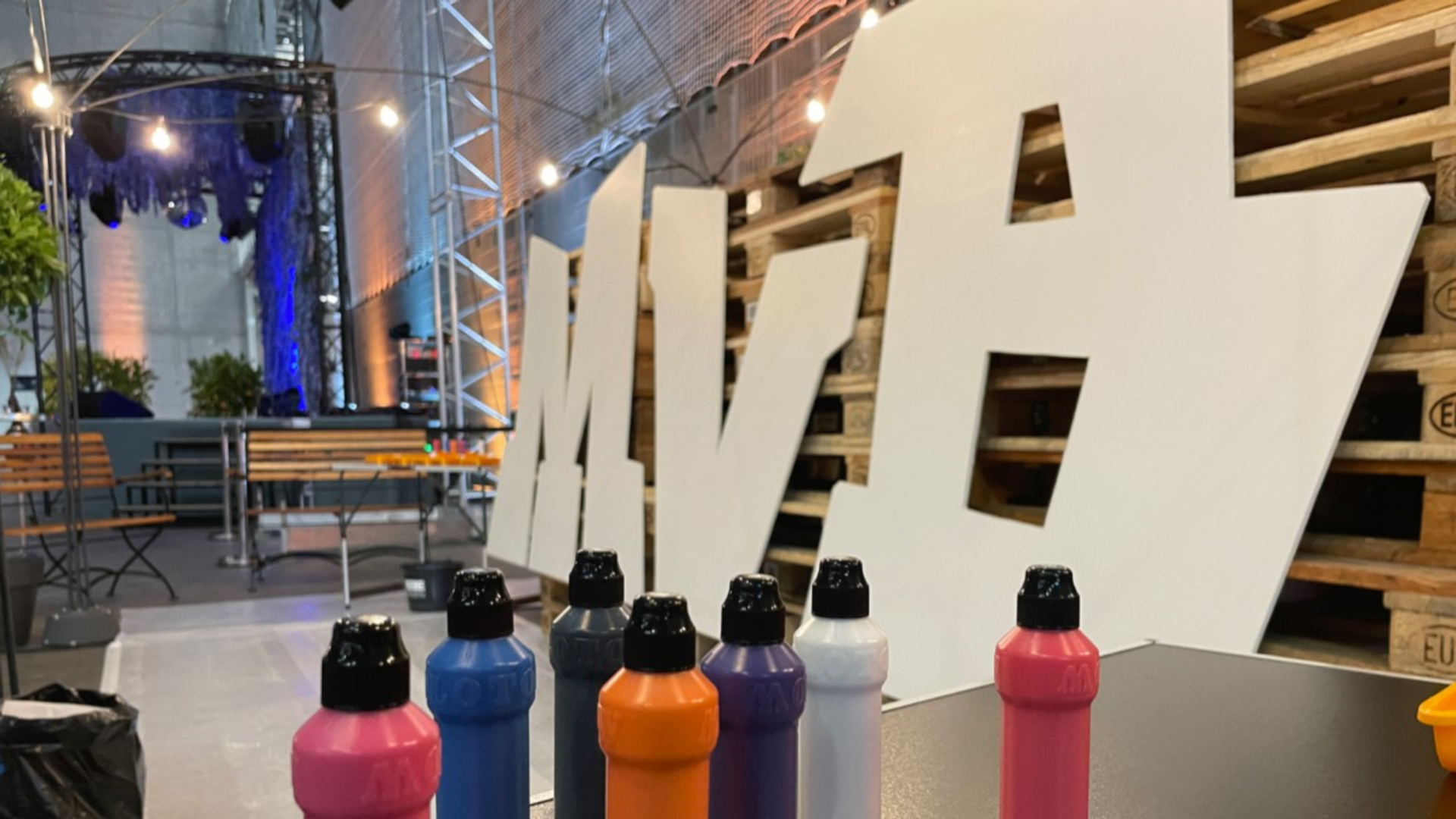 Large cut-out letters and colorful paint bottles