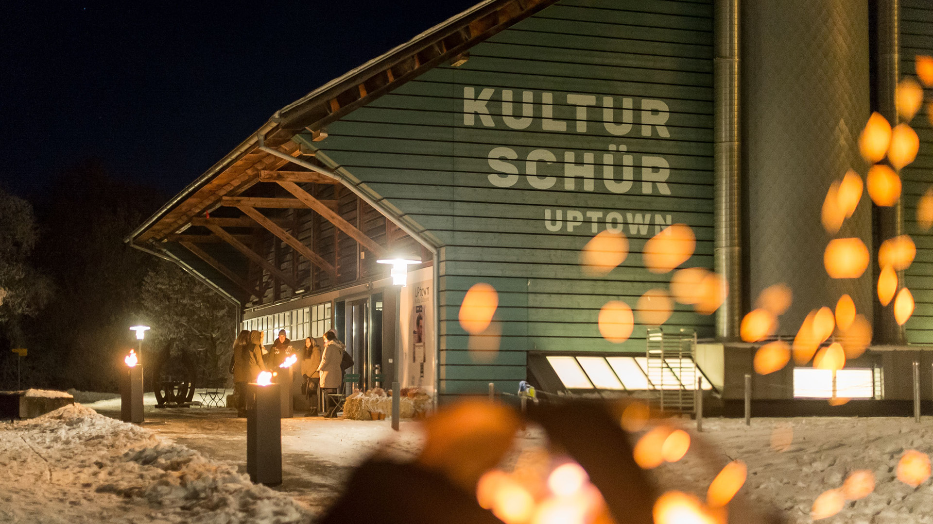 Kulturschür éclairé dans un paysage hivernal enneigé