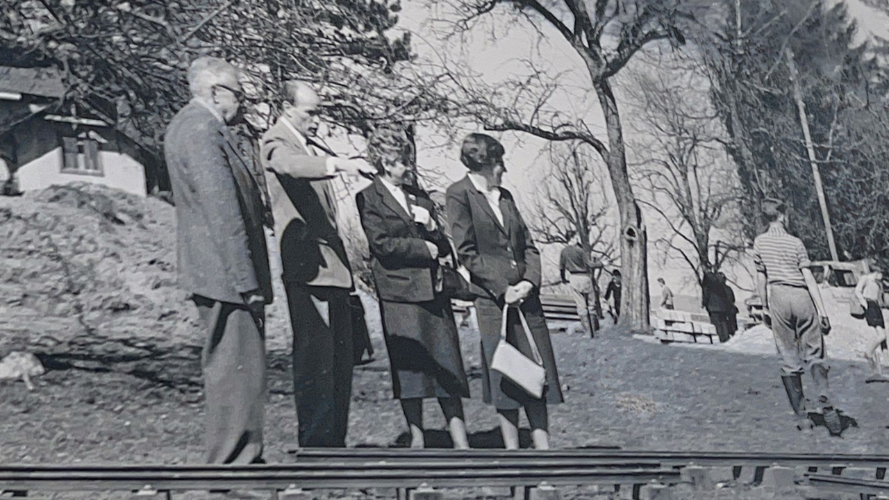 Older people looking at the small railroad.