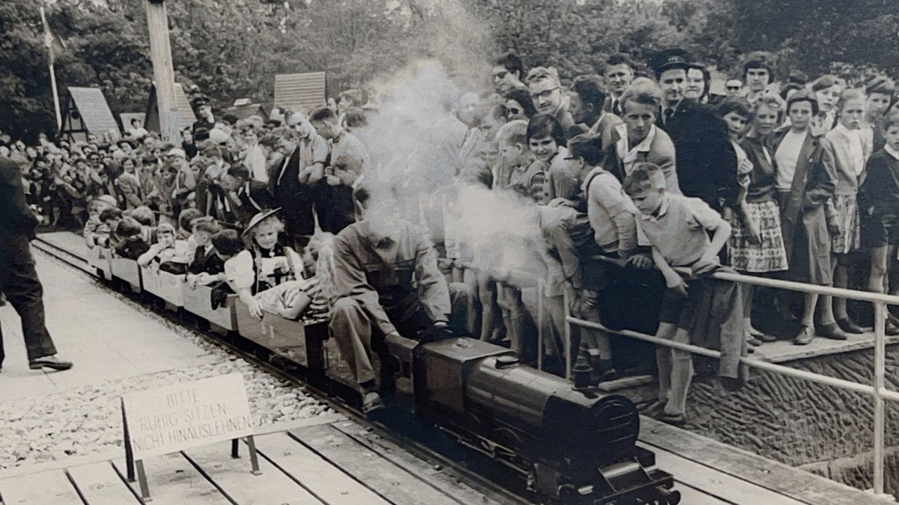 Premier voyage d'un petit train avec des spectateurs curieux