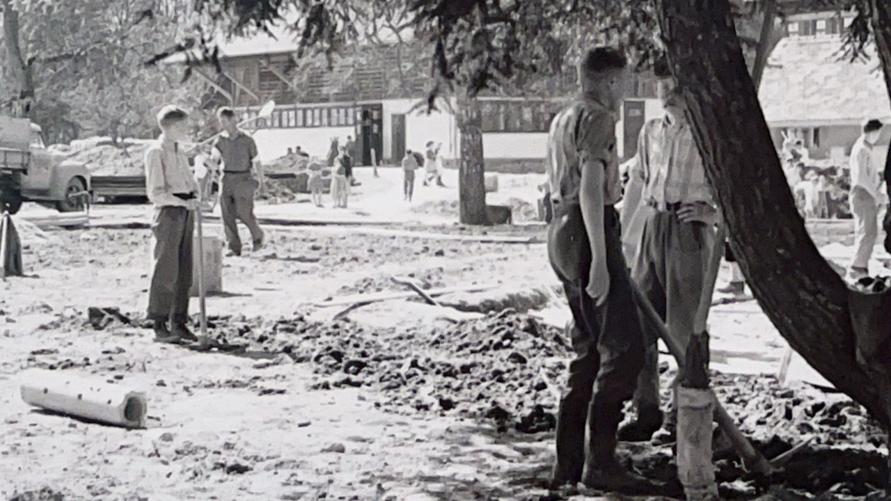 Boys shovel earth out of the ground.