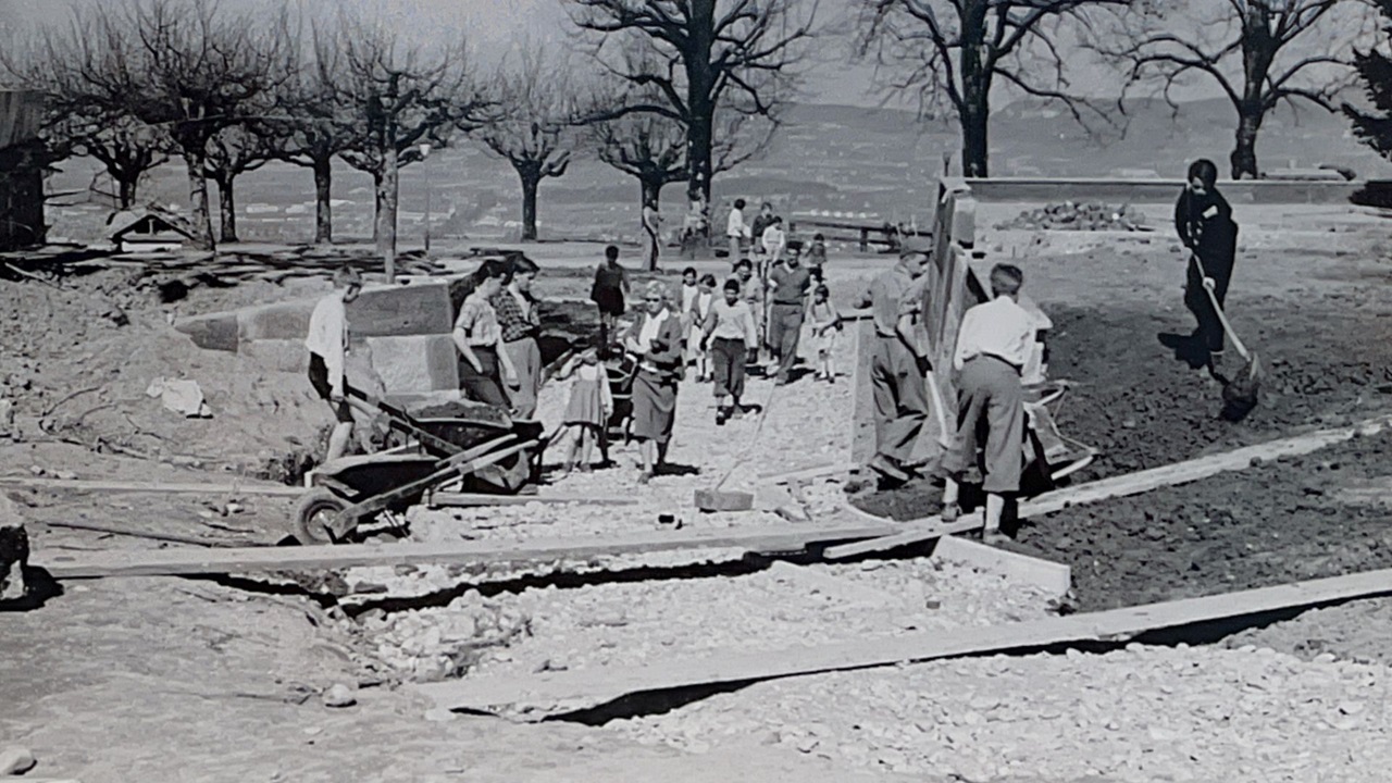 The boys and men build a small bridge for the locomotive.