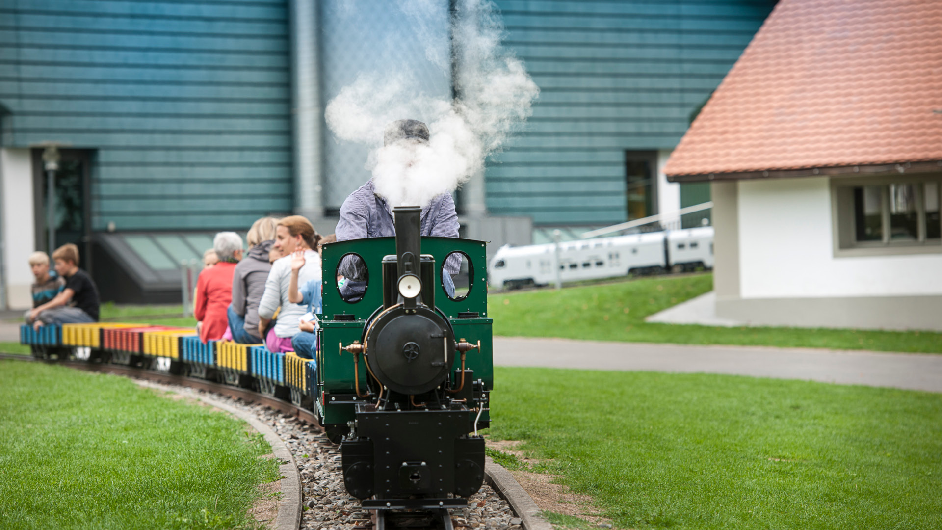 Une locomotive à vapeur fait un tour avec les enfants dans un nuage de vapeur