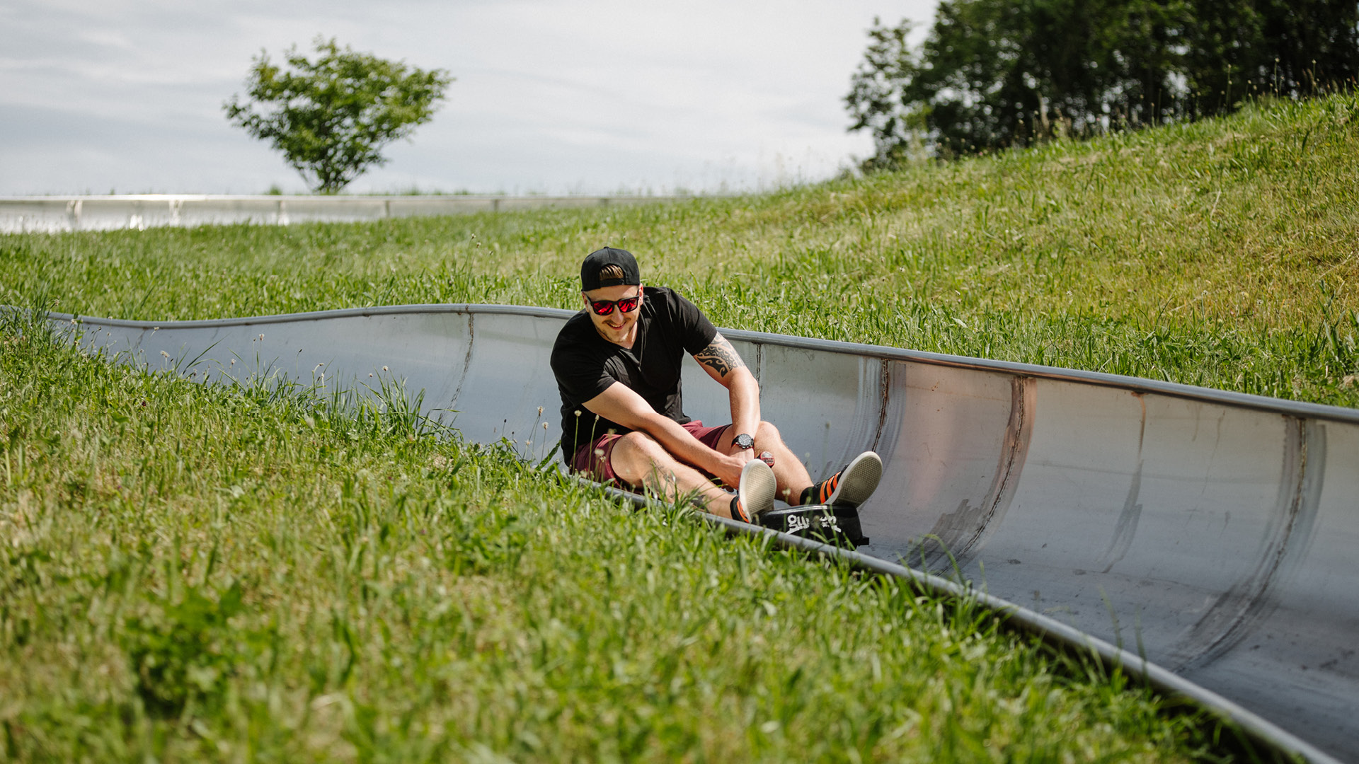 A person wearing a hat on the toboggan run in the summer