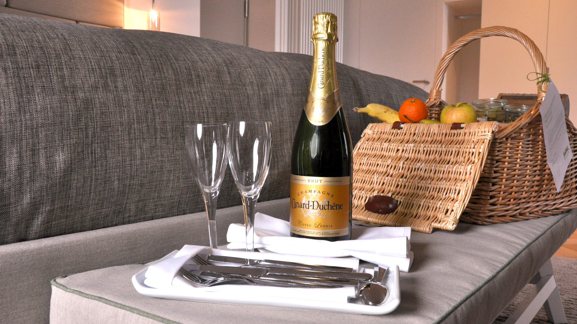 Champagner mit zwei Gläsern und einem Picknickkorb für romantische Stunden.