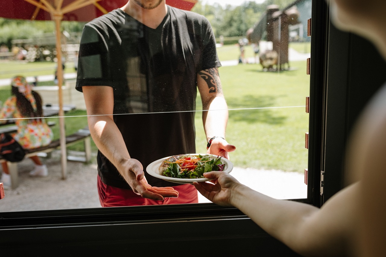 Ein Mann erhält einen Salat beim Take-away-Stand.