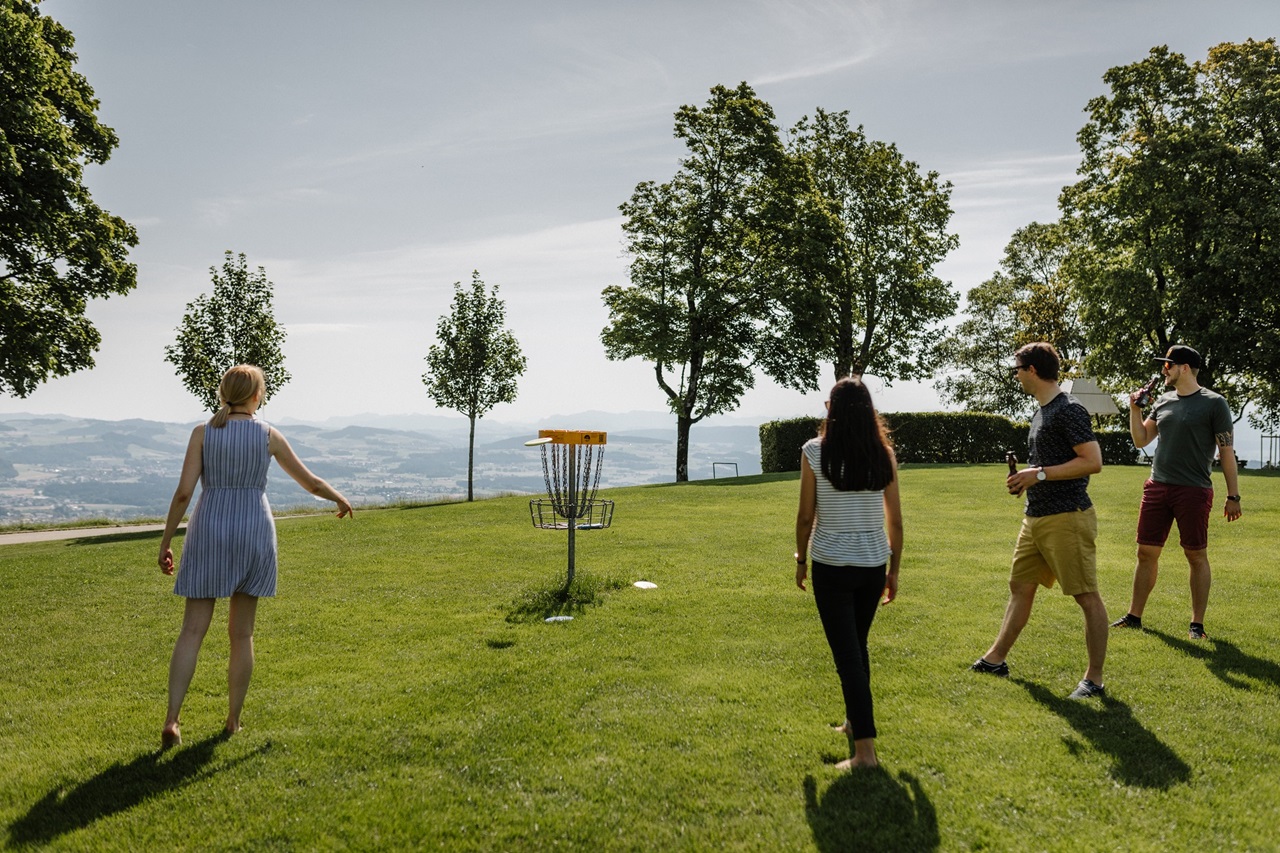 Eine Gruppe junger Menschen spielt vergnügt Frisbee auf dem Gurten.