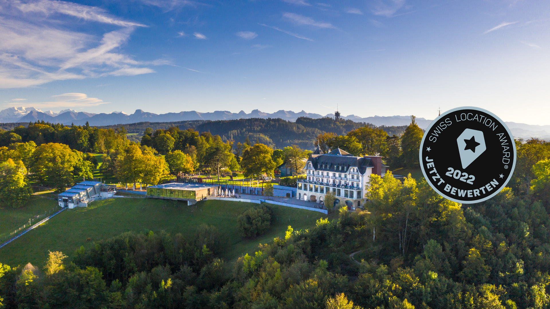 Bild mit Drohnensicht auf den Gurten – Park im Grünen und dem Swiss Location Award Nominierungsbutton