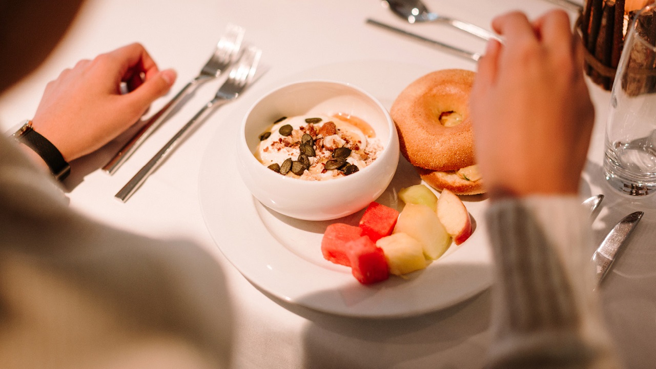 Müesli, Bagel und Früchteauswahl auf einem Teller beim vegetarischen Brunch