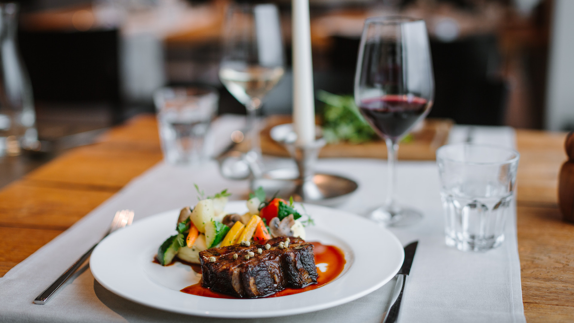 24-hour braised beef rib with vegetables and a glass of wine