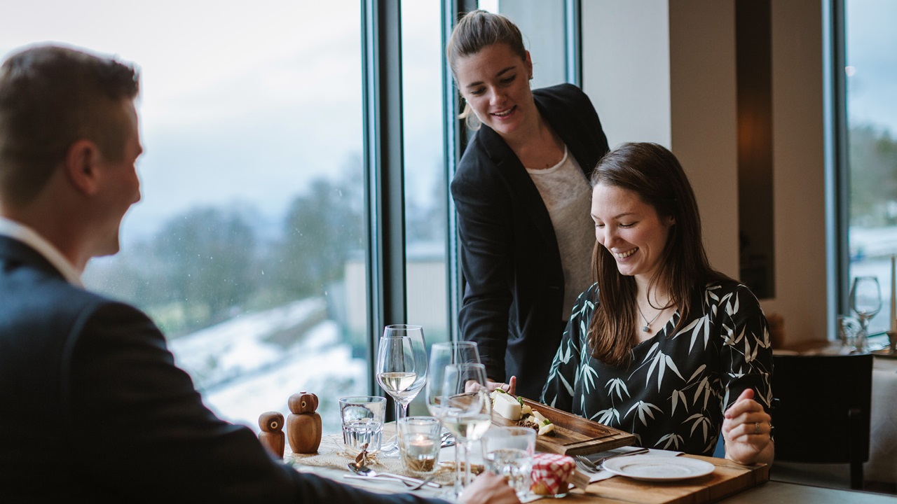 Spannende Jobs auf dem Gurten – Chef de Service bedient junges Paar im Restaurant Gurtners