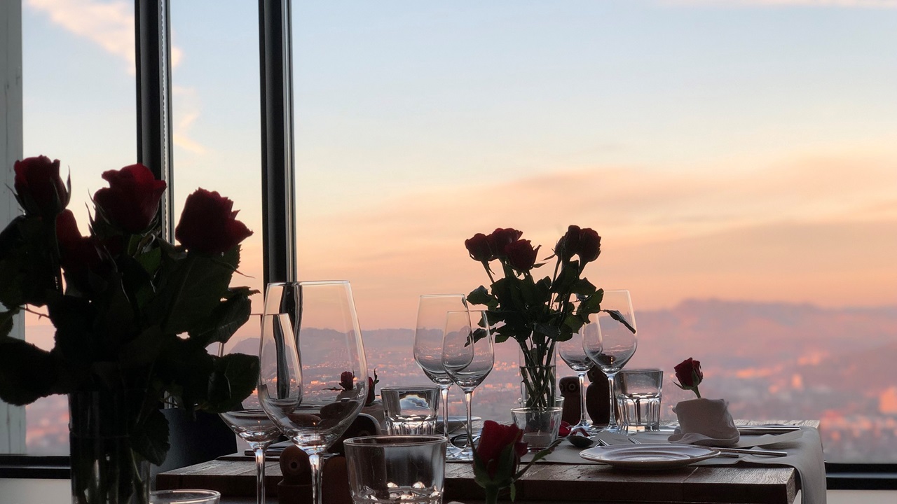 Ein romantisches Ambiente im Restaurant. Rote Rosen stehen auf dem Tisch. 