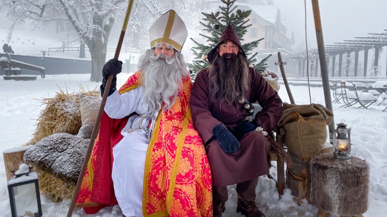 St. Nikolaus mit seinem Gehilfe auf der Bank.