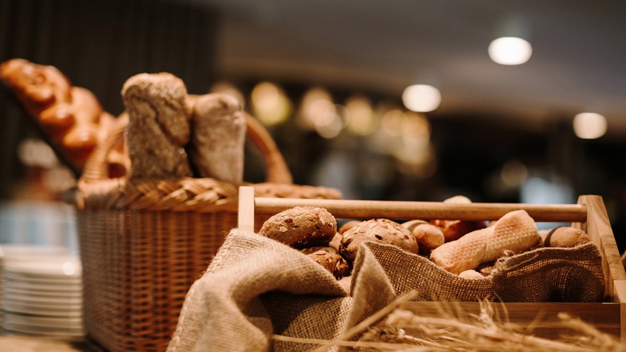 A close-up of bread the Bauernbrunch. Two baskets of bread and a stack of plates can be seen.