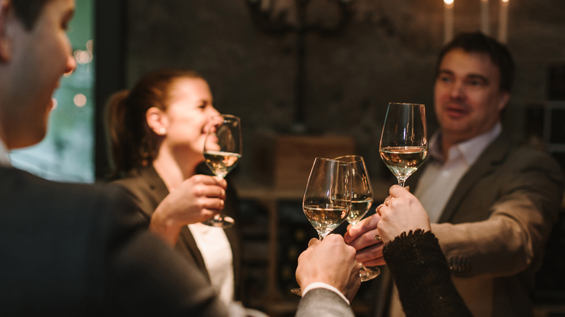 Plusieurs personnes trinquant avec du vin blanc.