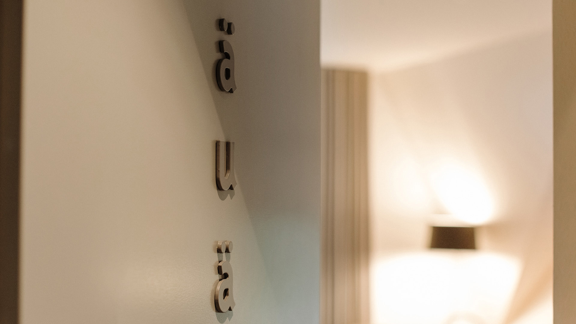 Die Türe des Hotelzimmers ist mit dem 3D-Schriftzug "äuä" geschmückt.