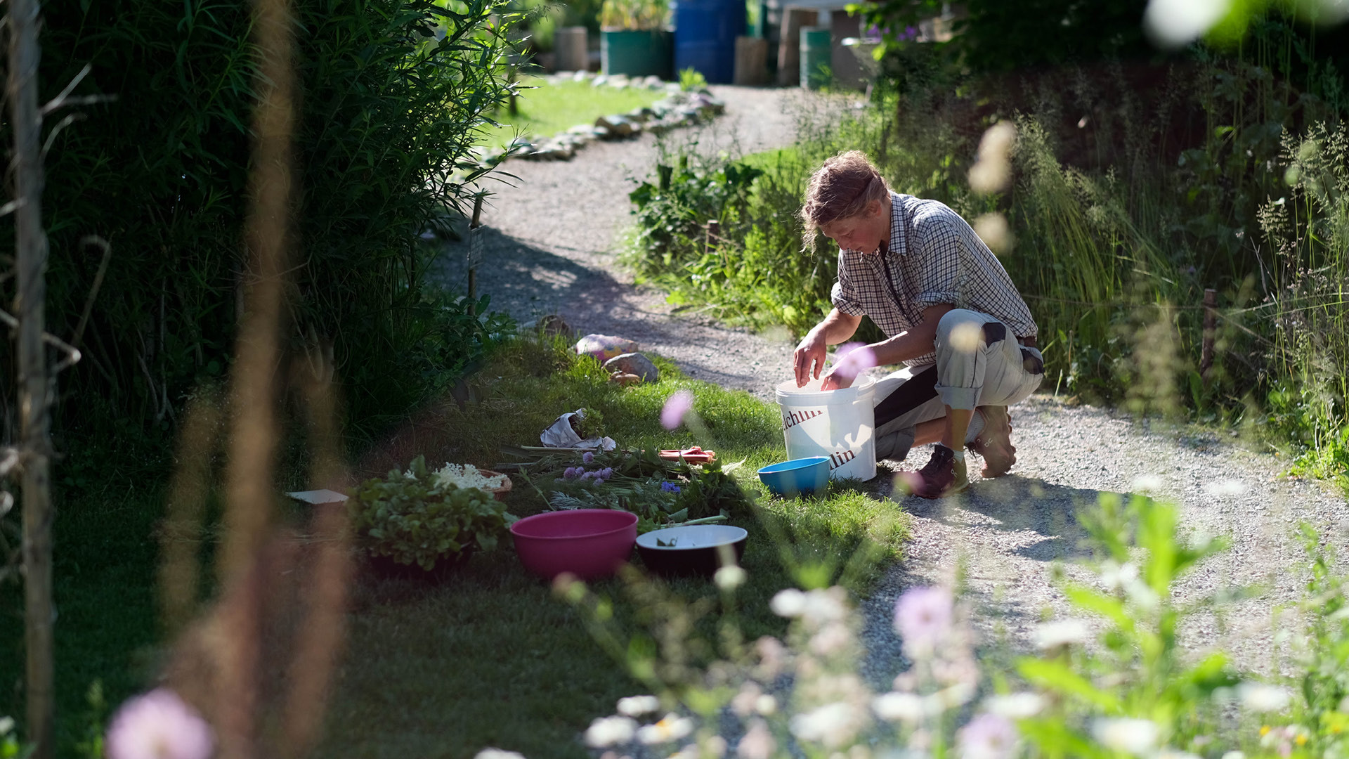 Une femme qui prend quelque chose dans un seau dans le Gurtengärtli.