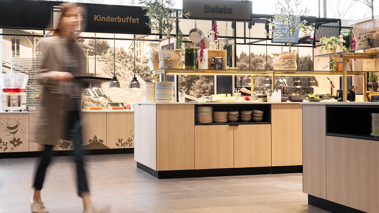 A woman walking past the various brunch buffets at Huusbüfe.