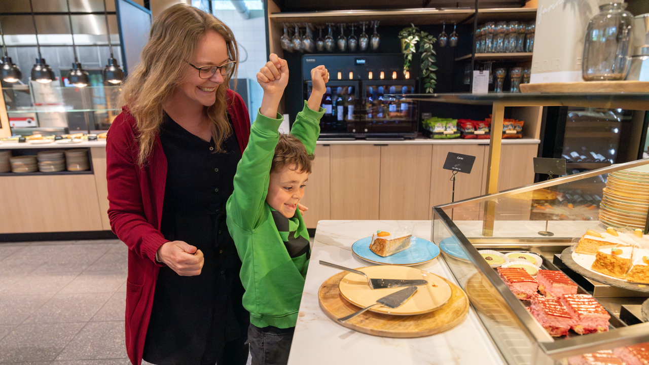 Ein Kind mit seiner Mutter, welches sich über das Kuchenbuffet beim Brunch im Huusbüffe freut.