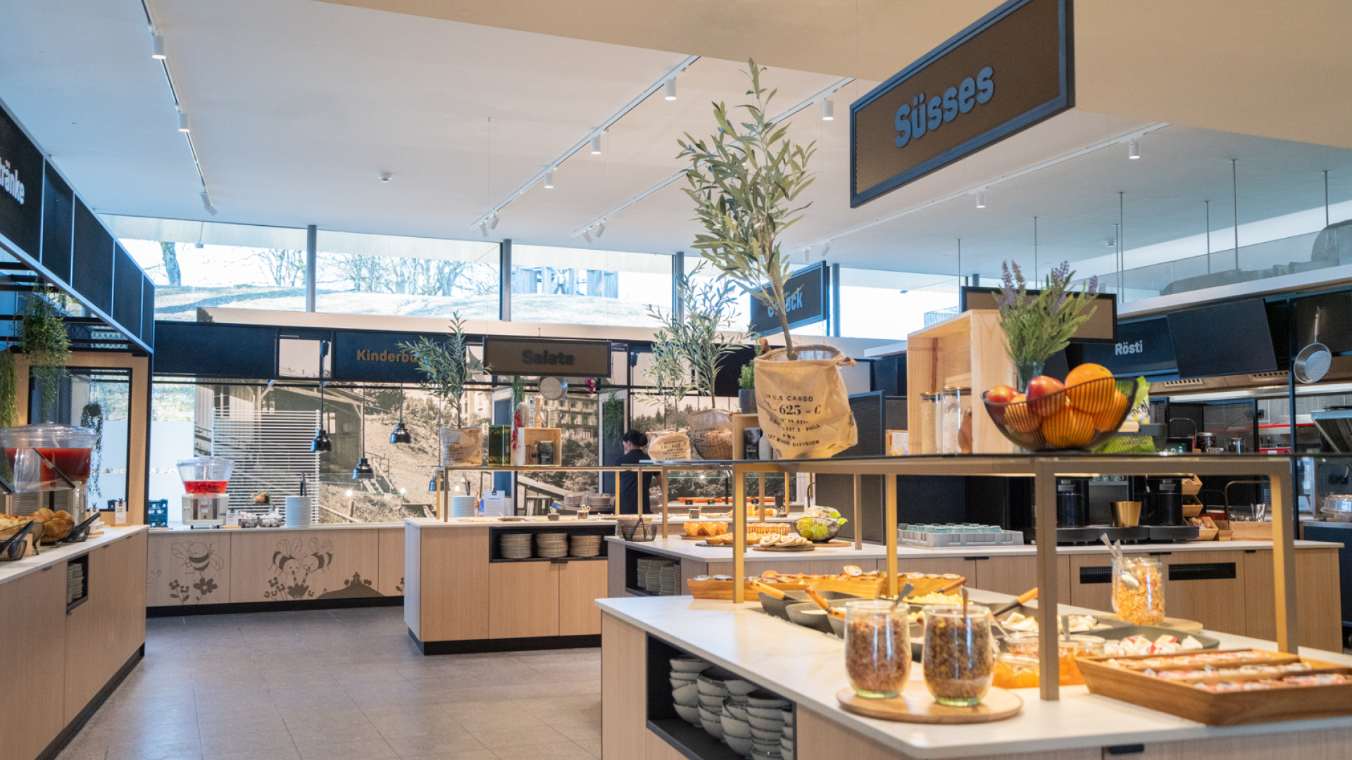Das Restaurant Huusbüffe mit Sicht auf die verschiedenen Buffets. Das Süsse Buffet enthält Müesli, Confituren, Früchte und Dekoration
