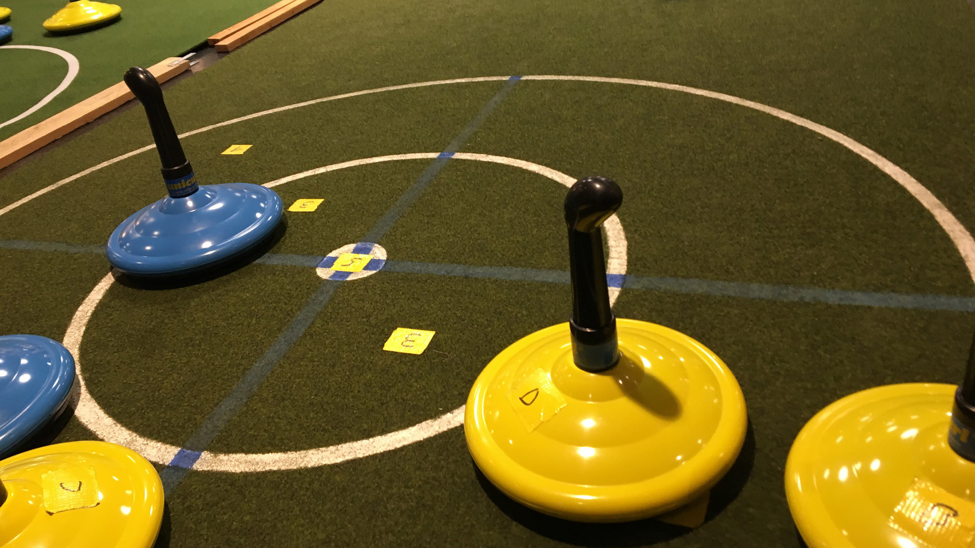 Curling stones scattered on artificial turf