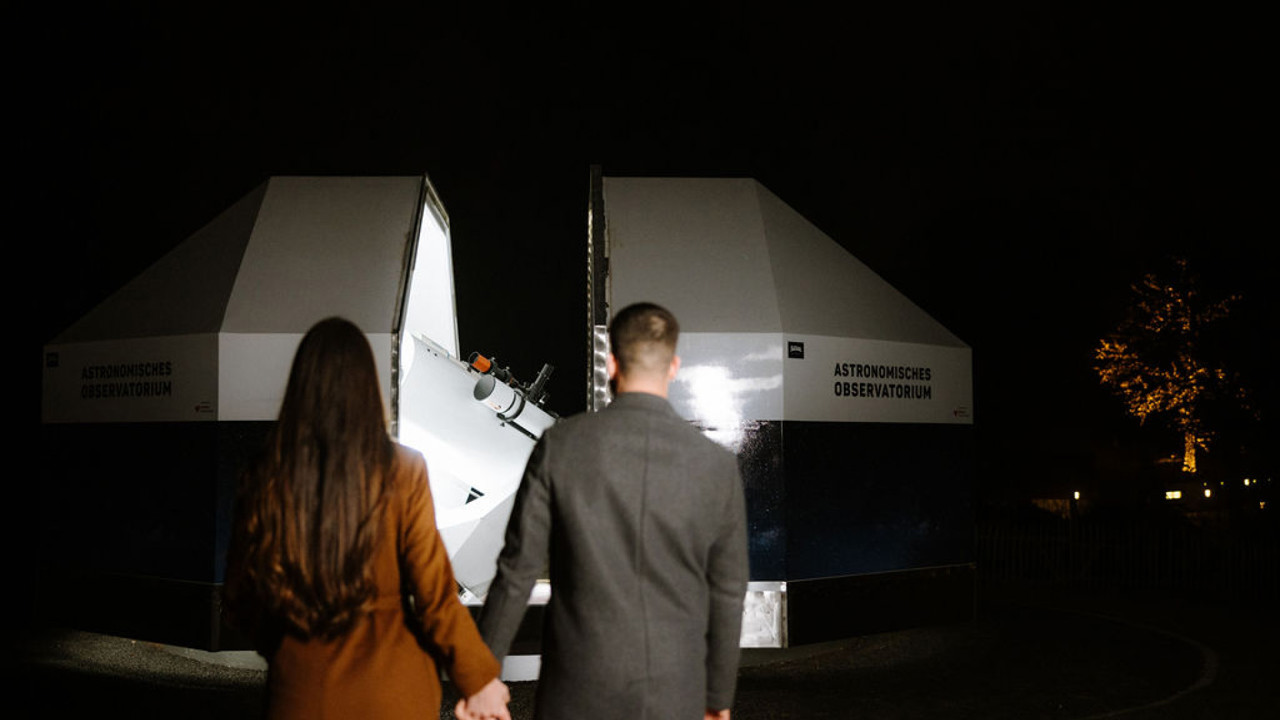 Two people walking towards the Gurten observatory.