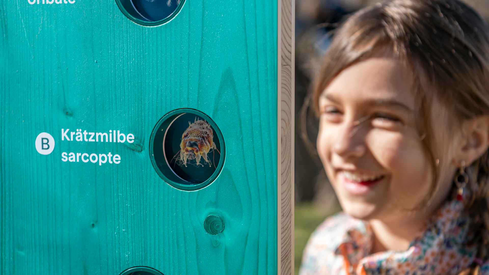 Ein Kind welches eine Informationstafel im Gurten - Park im Grünen anschaut.