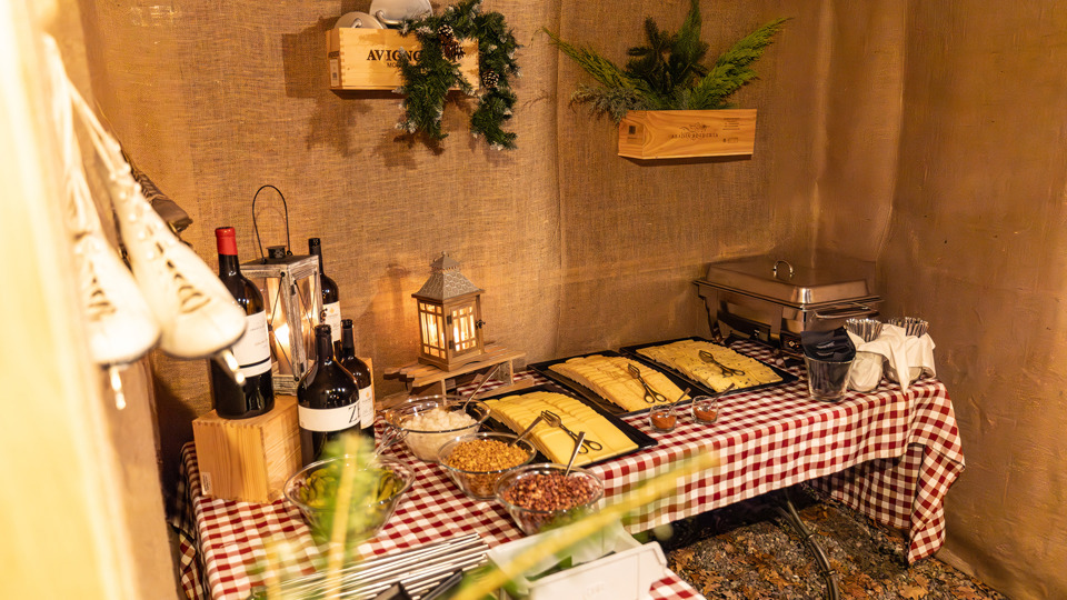 Buffet de raclette dans un chalet décoré sur le thème de l'hiver, au village d'hiver du Gurten