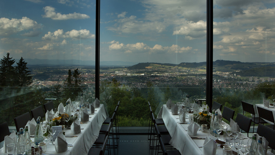 Gedeckte lange Tische an der Glasfront von dem Event-Juwel Pavillon.