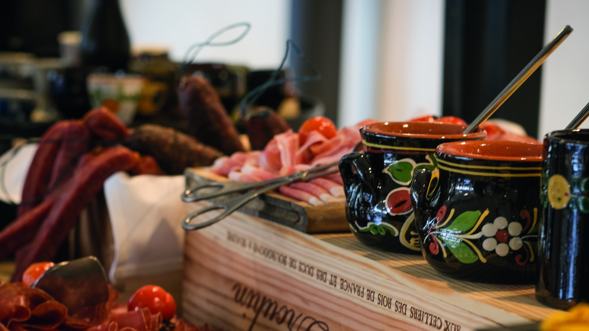 A close-up of the Schüür brunch. Various sausages, meat, and several clay pots can be seen.