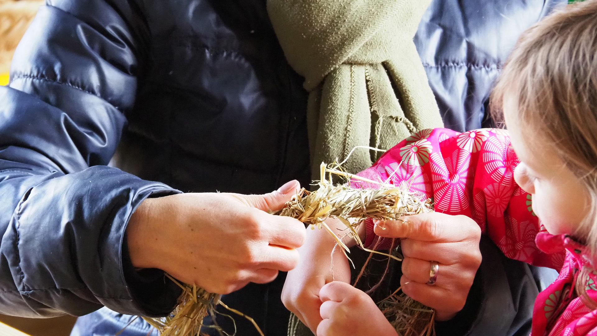 A child making a ring out of straw.