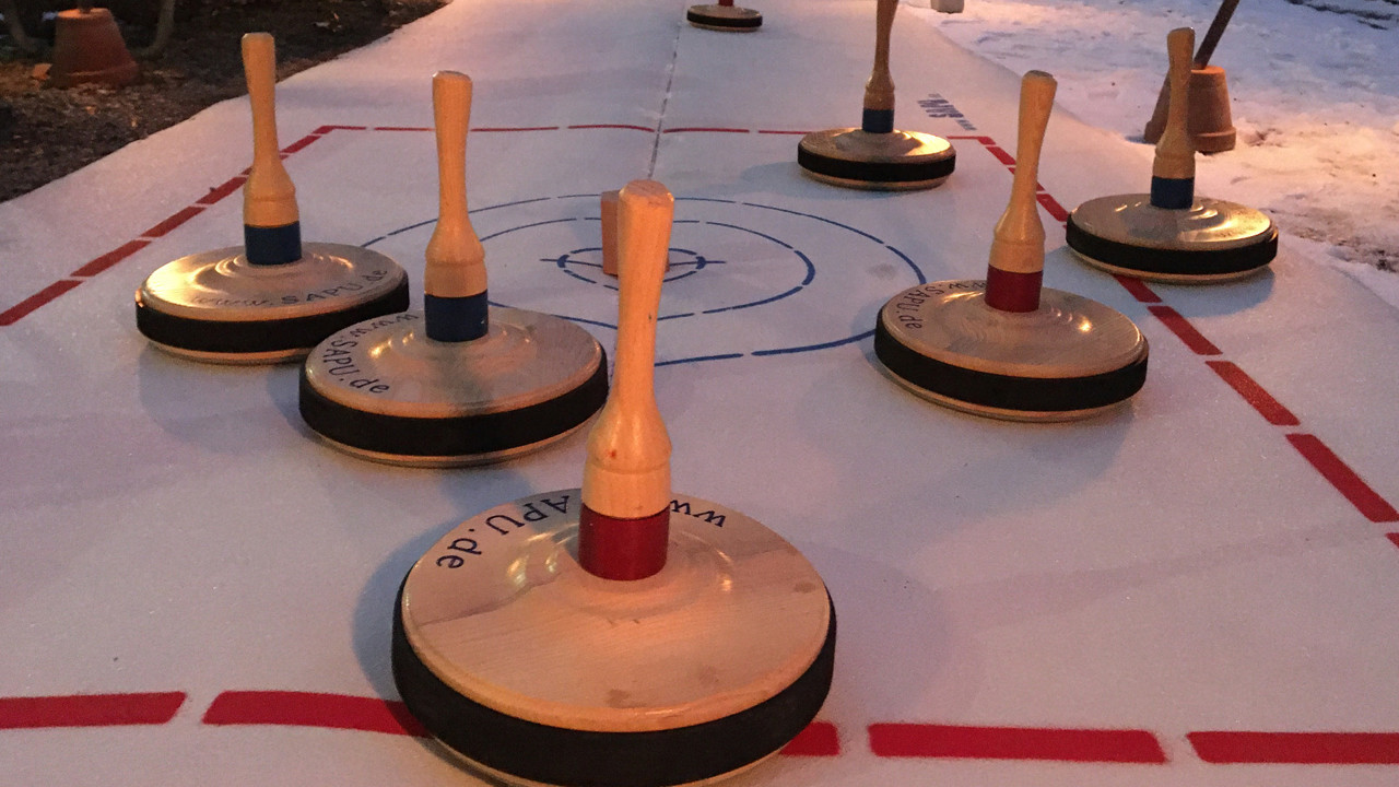 Curlingsteine auf Eisbahn verteilt
