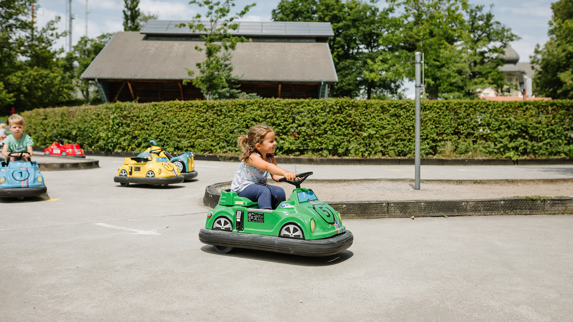 Kind auf grünen Kids Car in Spielpark