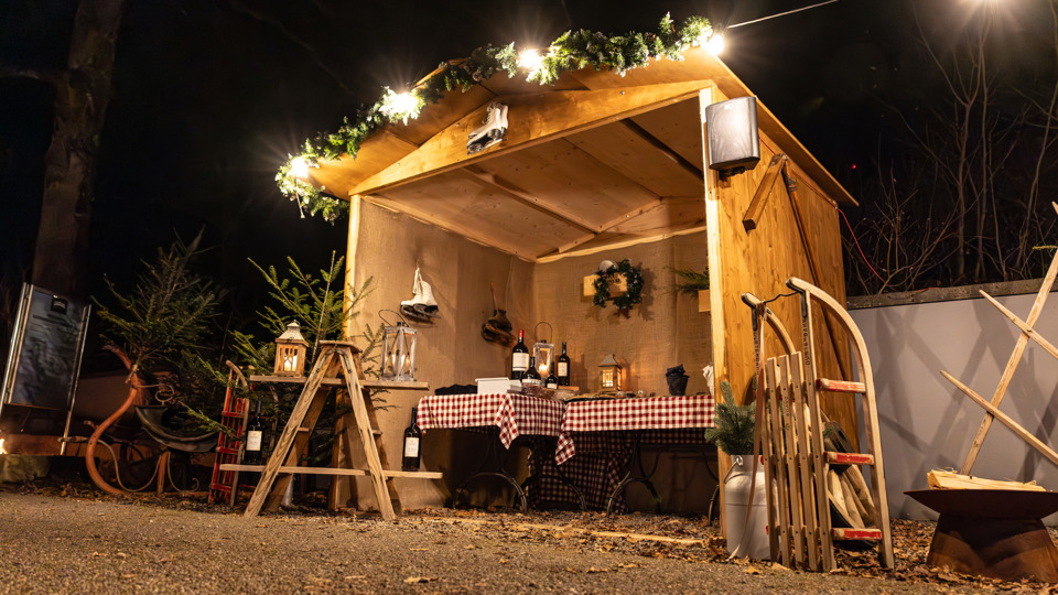 Village d’hiver sur le Gurten avec un chalet en bois décoré pour les fêtes.
