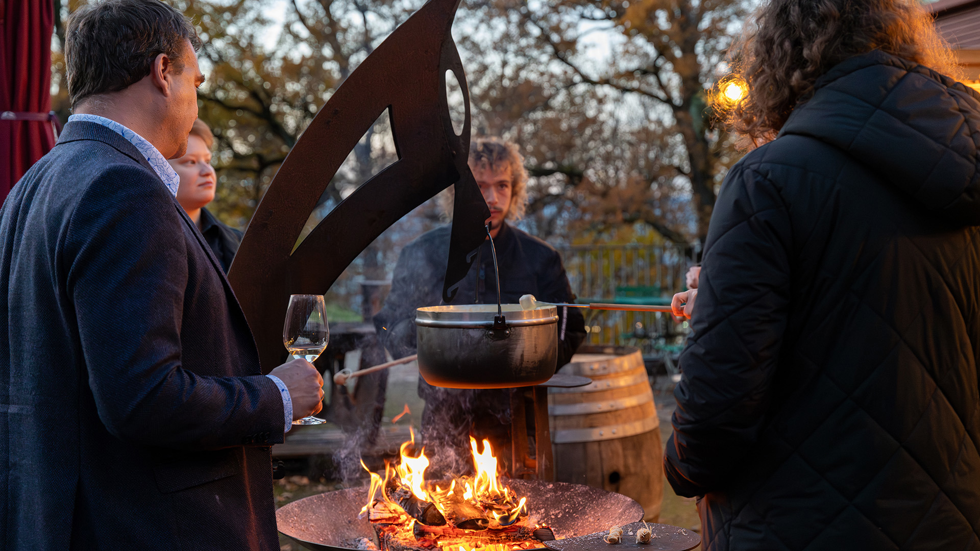 Un groupe autour d'un feu de camp dans le village d'hiver, en train de manger une fondue.