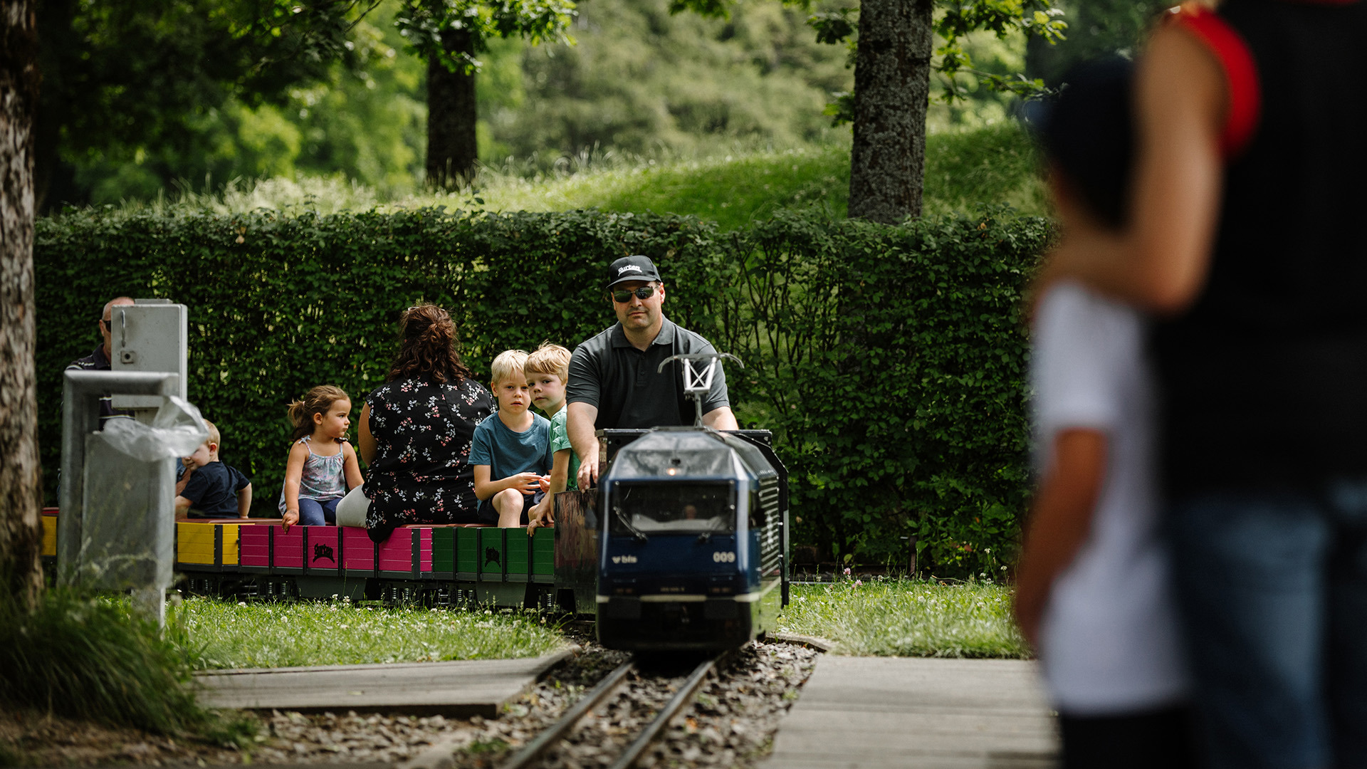Small train with passengers entering station