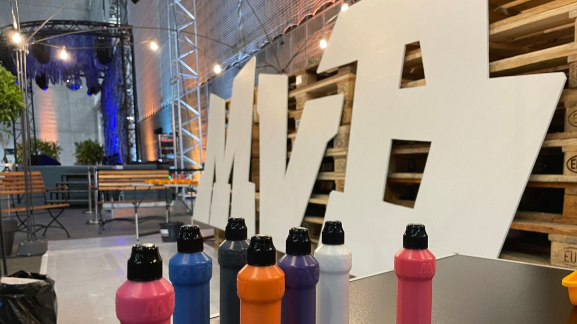 Bunte Spraydosen vor Leinwand