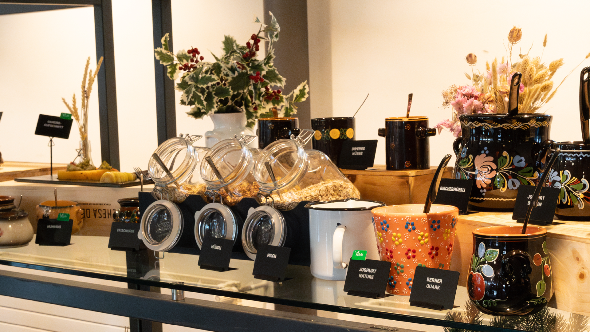 Several bowls at the Schüürbrunch with various cereals, yogurts, nuts, and decorations.