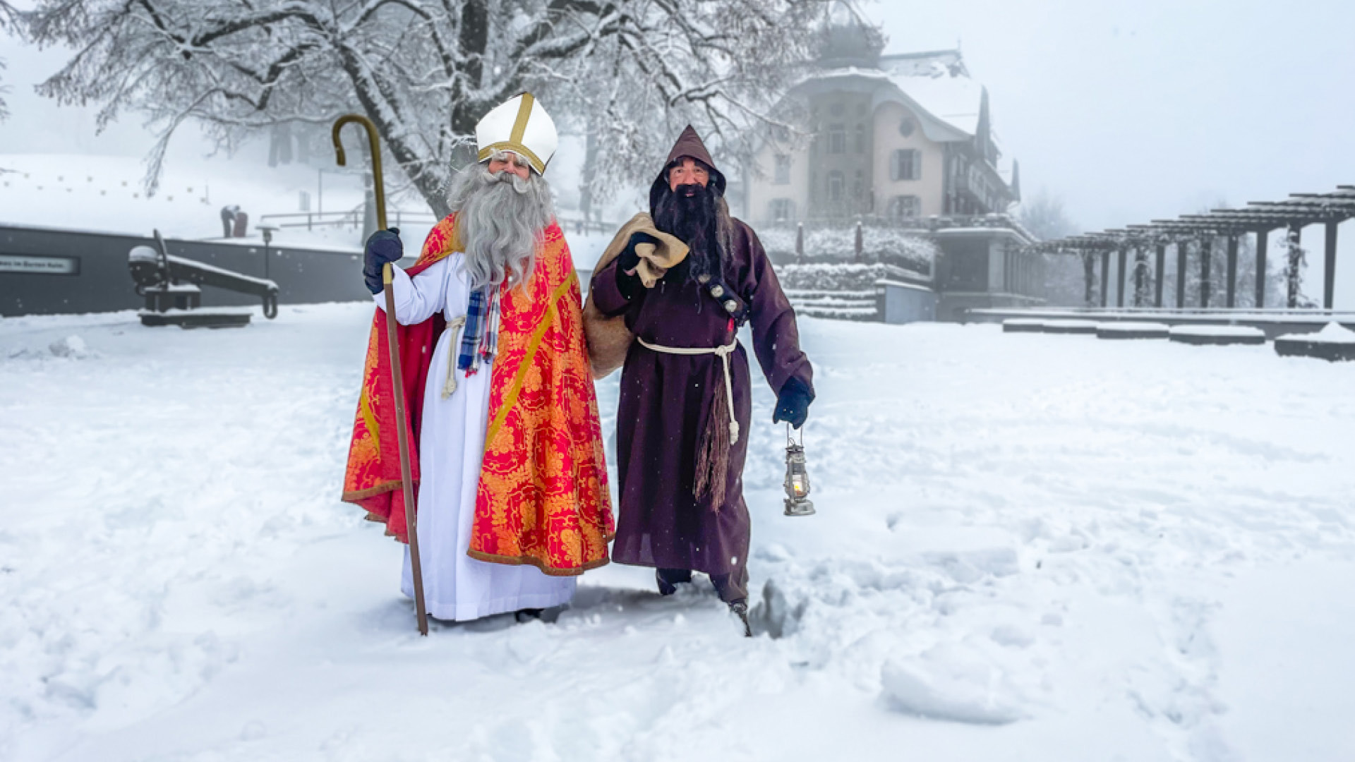 Saint-Nicolas et le Père Fouettard pataugent dans la neige.