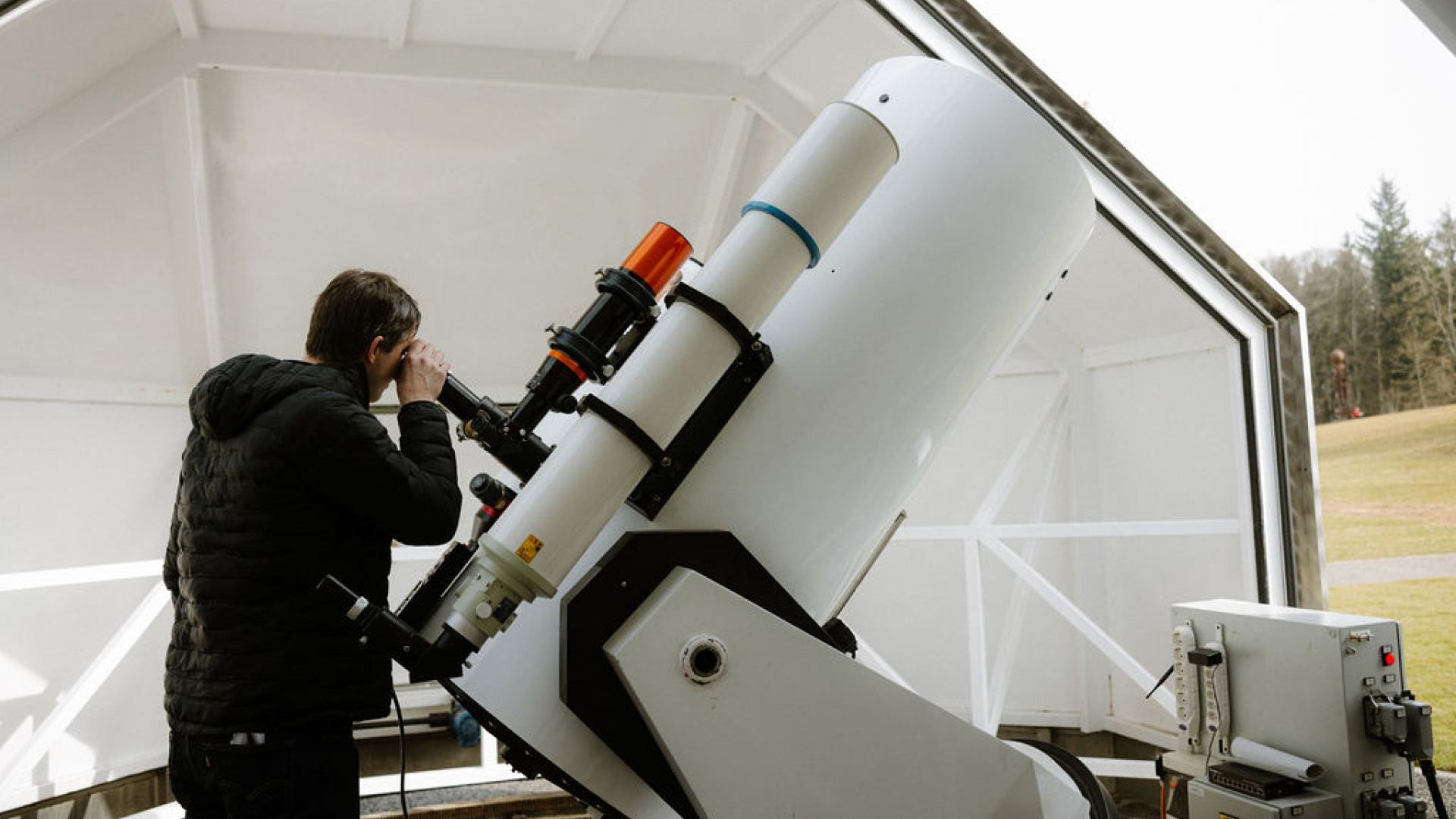 Man watching a solar eclipse through a telescope at the Gurten Observatory.