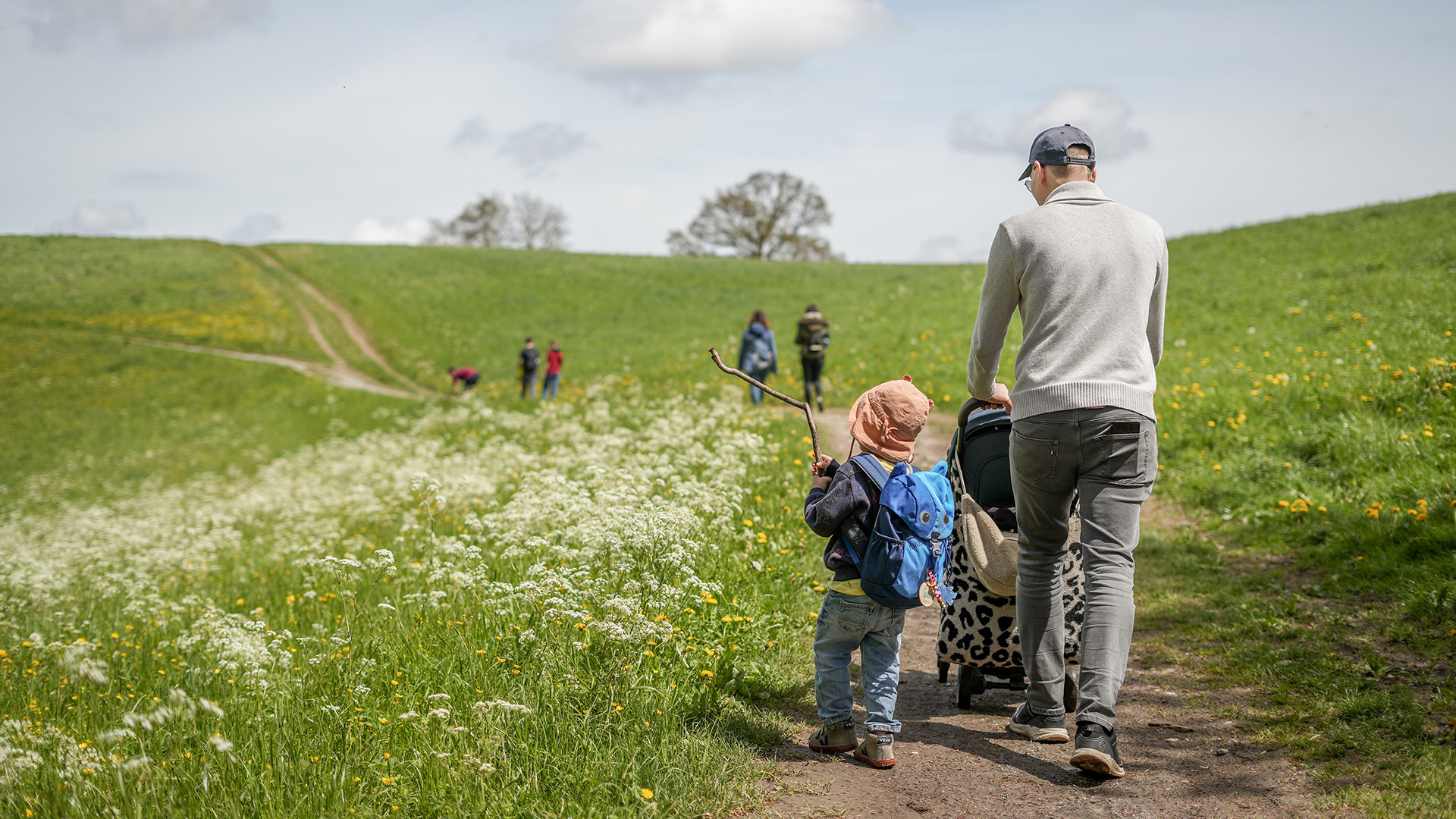 A father hikes up the Gurten with his children.