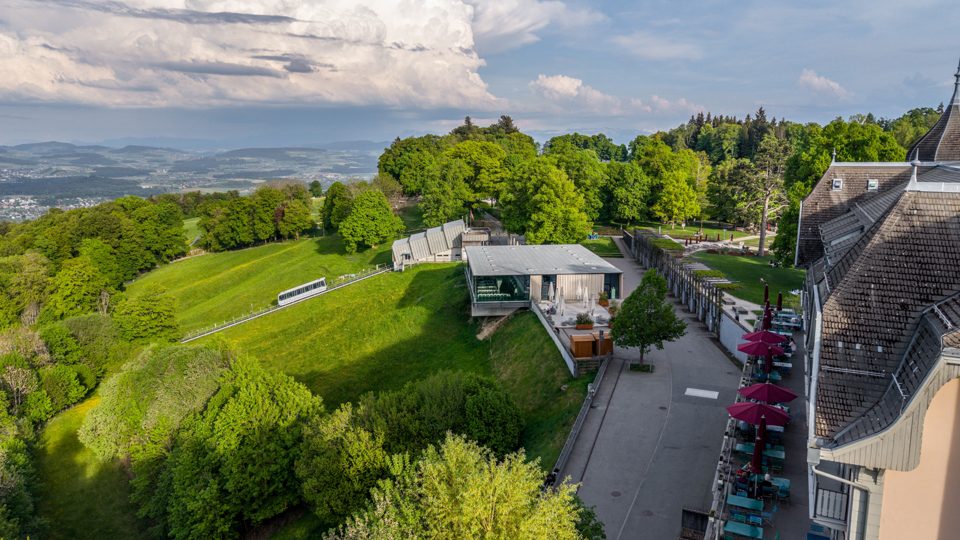 Der überhängende Pavillon und dahinter die silberne Gurtenbahn