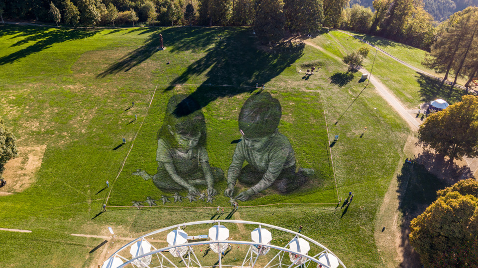 Saype's artwork on Gurten with the Ferris wheel overlooking the Bernese landscape.