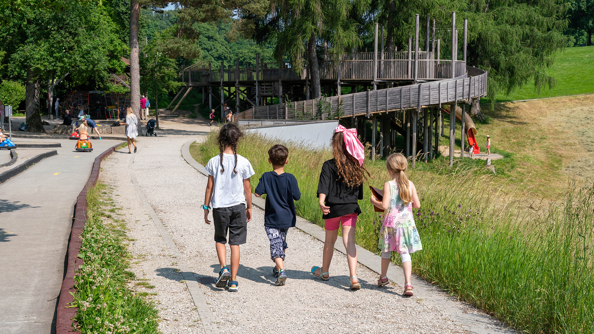 Vier Kinder gehen über Spielpark bei Kids Car